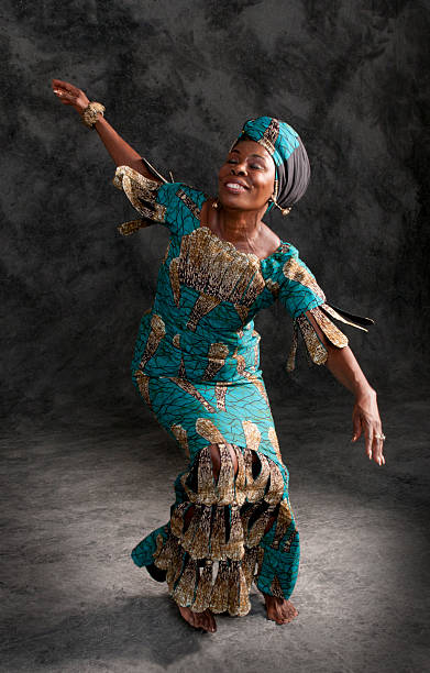 African dancer Black female African dancer in authentic African clothing and headdress telling a story with her body and hands. Studio lighting and background in vertical format.http://www.garyalvis.com/images/conceptsIdeas.jpg ceremonial dancing stock pictures, royalty-free photos & images