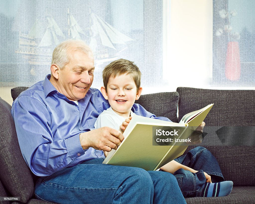 Grand-père et son petit-fils lecture livre - Photo de 6-7 ans libre de droits