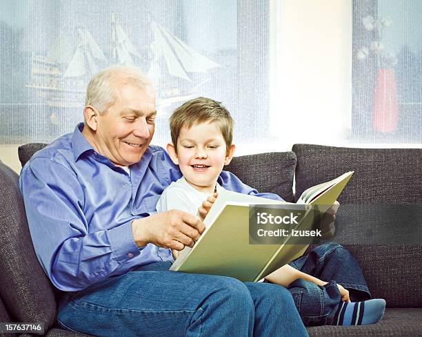 Photo libre de droit de Grandpère Et Son Petitfils Lecture Livre banque d'images et plus d'images libres de droit de 6-7 ans - 6-7 ans, 60-64 ans, Adulte