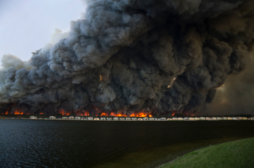 Brush fire behind houses by a lake, Miramar, Florida, USA
