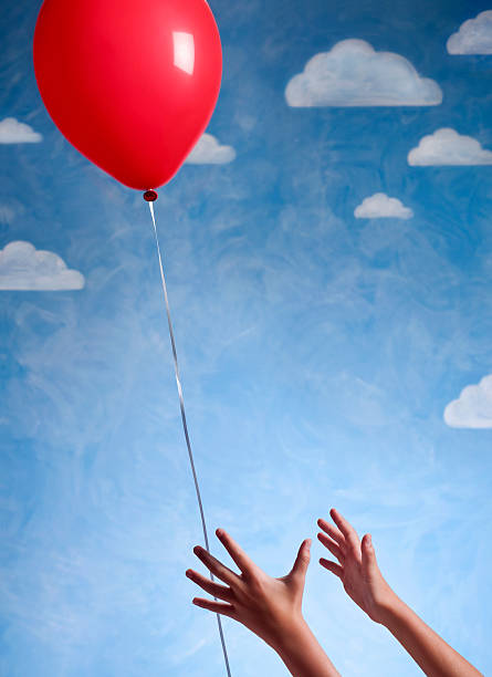 istock Little Girl's Hand Reaching For Red Baloon 157637639