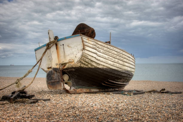 istock Old motor boat anchored on shingle beach 157637686