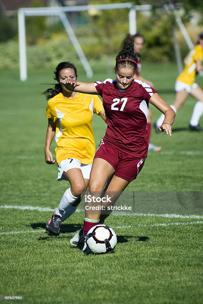 Dribbling Female Soccer Player Breaks Away From Defense Dynamic striker dribbles escapes defender. Soccer Stock Photo