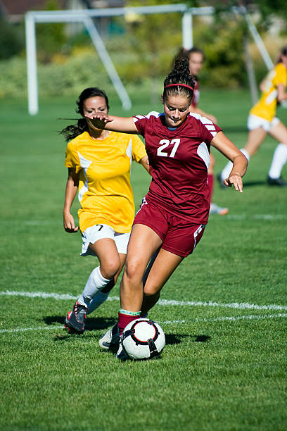 Dribbling Female Soccer Player Breaks Away From Defense stock photo