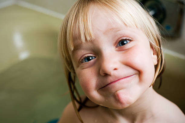 Adorable little girl, 7 years old, makes an angry face at the camera