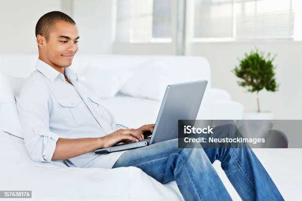 Foto de Jovem Trabalhando No Laptop Em Casa e mais fotos de stock de 20 Anos - 20 Anos, Adulto, Alegria