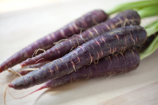 Close-up shot of a bunch of purple carrots.