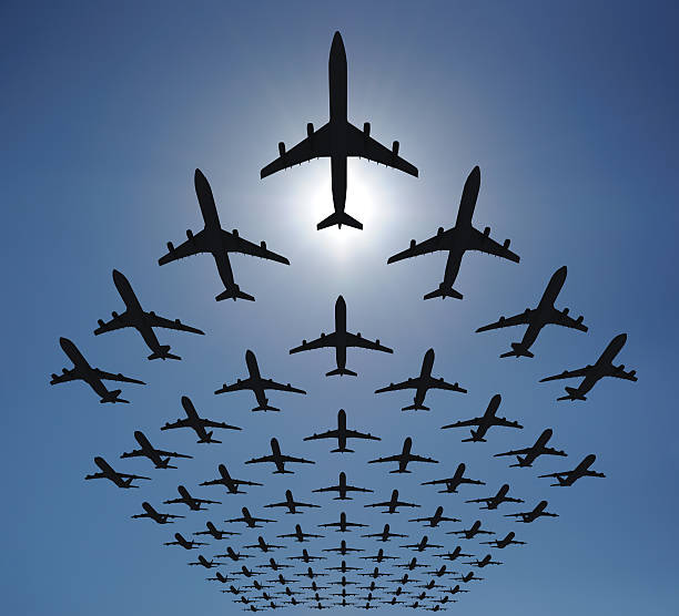 Rows of many planes flying in the sky. Clear blue sky, shot against the sun. Check out some other aviation files:\n[url=http://www.istockphoto.com/file_search.php?action=file&lightboxID=8986312]\n[img]http://georgo.hu/stockphoto/in-the-sky-lightbox.jpg[/img][/url]\n[url=http://www.istockphoto.com/file_search.php?action=file&lightboxID=3394147]\n[img]http://georgo.hu/stockphoto/chartpromobusiness.jpg[/img][/url]