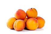 A pile of fresh apricots on a white background