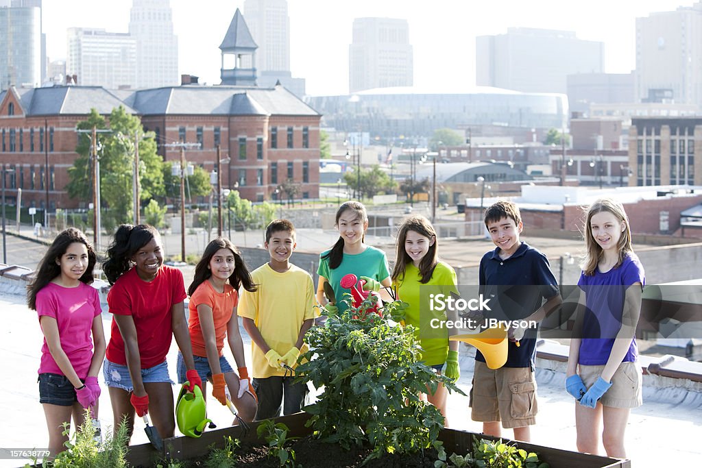 Go Green: Kindern unterschiedlicher Ethnien, die Pflege von Urban auf der Dachterrasse Garten - Lizenzfrei Teenager-Alter Stock-Foto