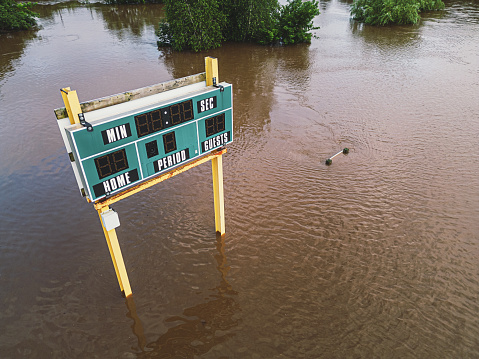 A scoreboard in a flooded sports field.