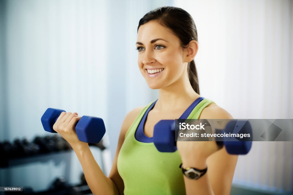 Mujer joven haciendo brazo Curls con Mancuernas - Foto de stock de 20 a 29 años libre de derechos