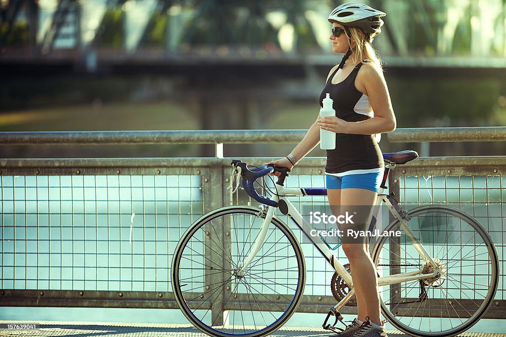 Ciclista mujer toma un descanso de agua - Foto de stock de Accesorio de cabeza libre de derechos