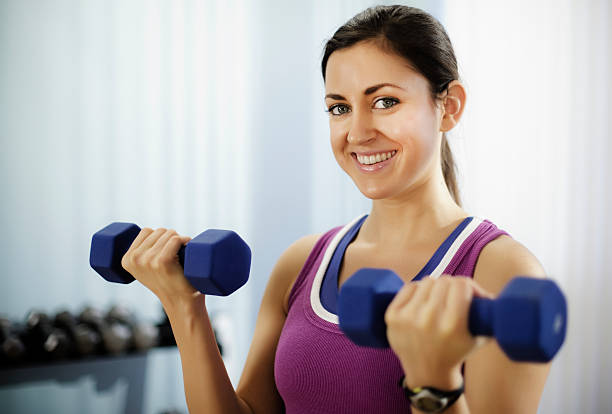 istock Young Woman Doing Arm Curls With Dumbbells 157639100