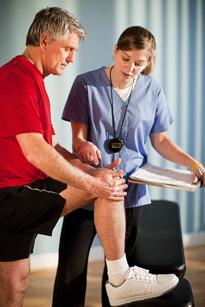 istock Physical Therapist Looking at Knee Injury 157639130