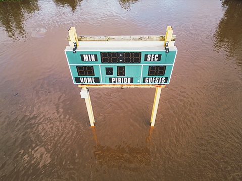 A scoreboard in a flooded sports field.