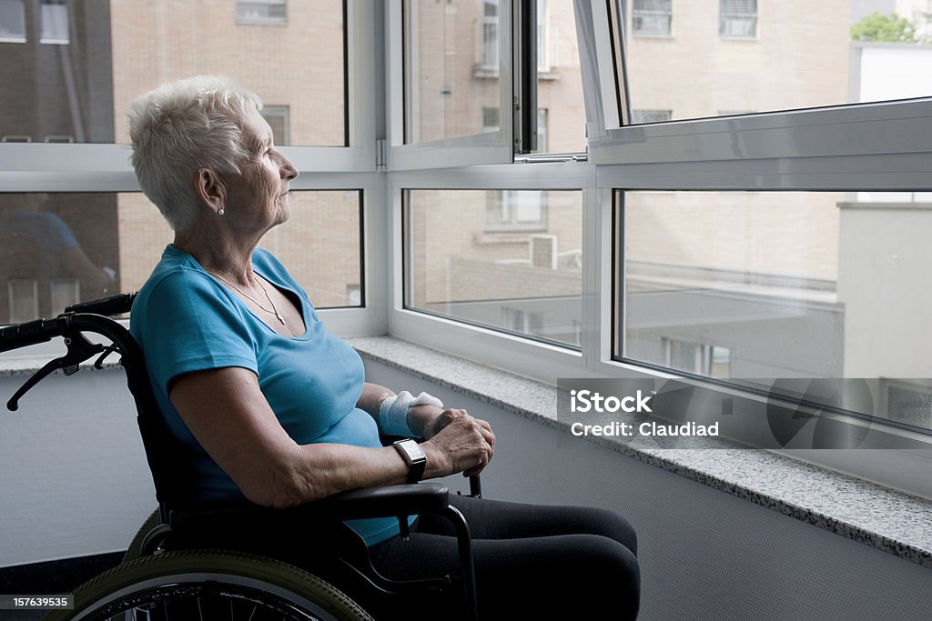 Mujer madura sentado en silla de ruedas - Foto de stock de Amputado libre de derechos