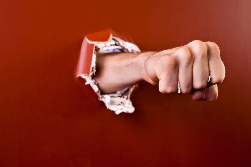 Man's fist coming through wall.