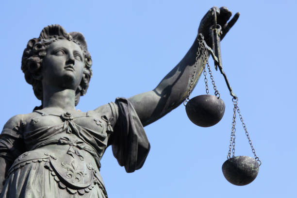 istock Lady Justice statue with scale against blue sky 157640217