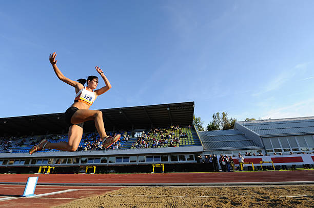 mujer atleta de salto - evento de prueba de campo feminino fotografías e imágenes de stock