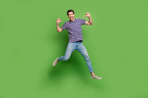 Little school boy jumping in the studio on a yellow background. Concept of happy childhood.