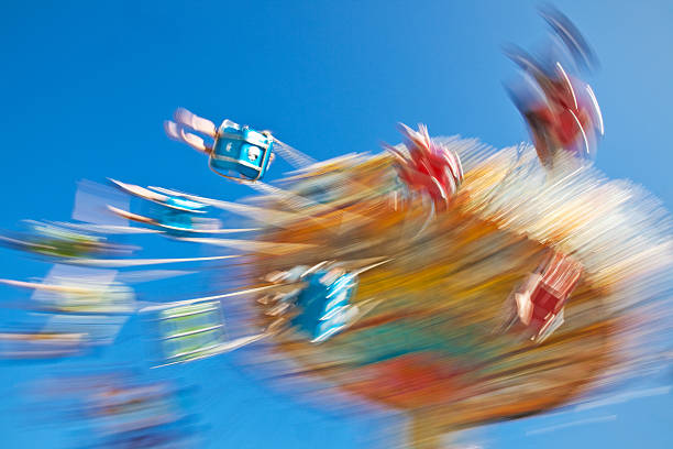 People Spinning on Carnival Swing Ride. Motion-Blur. stock photo