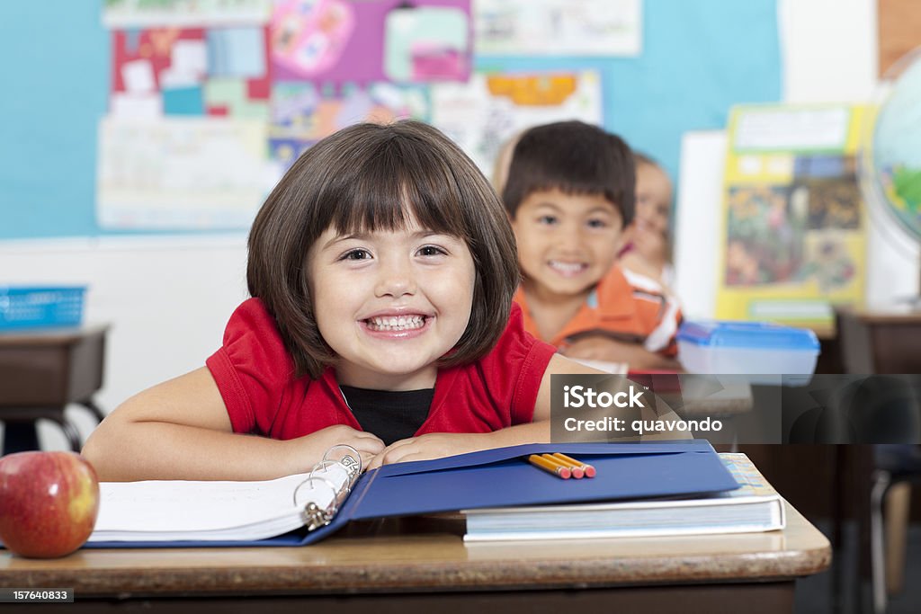 Encantadores sonriente de estudiantes en el aula de escuela primaria, origen étnico mixto - Foto de stock de Alegre libre de derechos