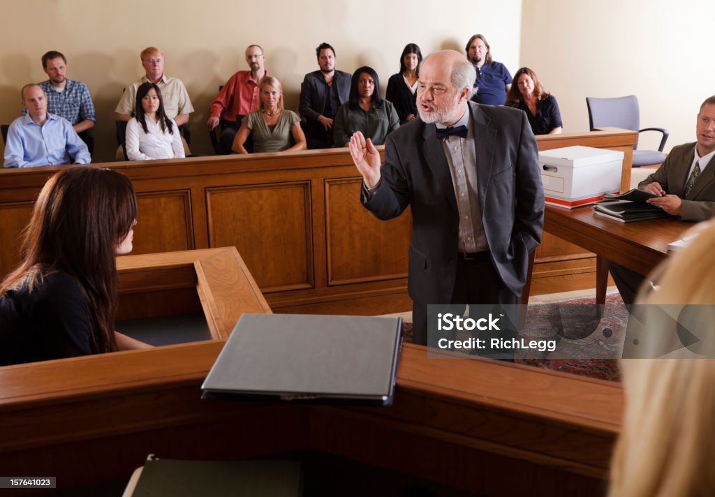 Lawyer in a Courtroom A lawyer questioning a witness in front of the jury in a courtroom. Courthouse Stock Photo