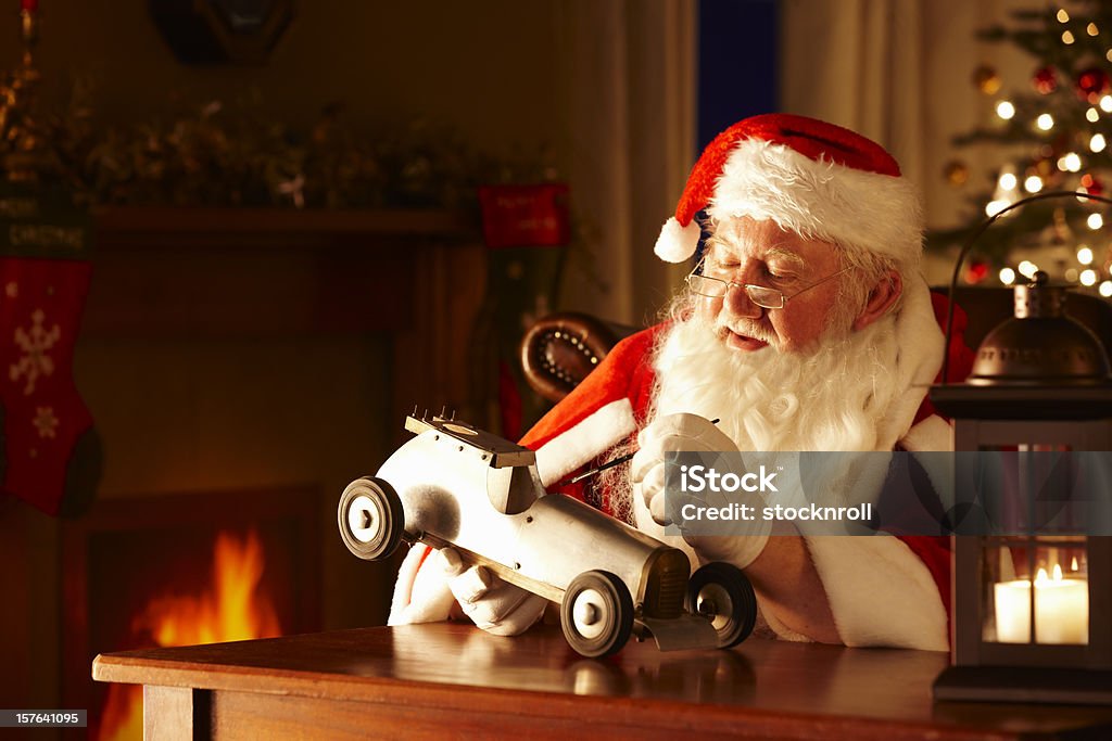 Father Christmas malen ein Spielzeugauto in seiner Werkstatt - Lizenzfrei Weihnachtsmann Stock-Foto