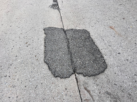 Asphalt patch on concrete