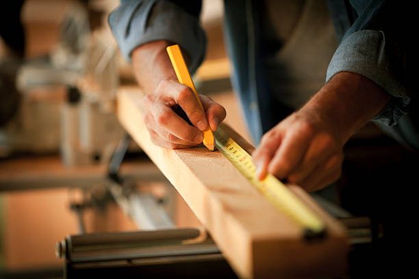 carpentiere di una tavola di legno - carpenter home addition manual worker construction foto e immagini stock