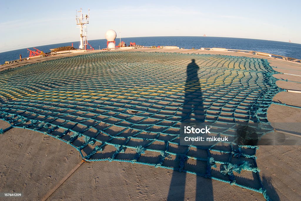 shadow of man sur helideck de plate-forme pétrolière - Photo de Hélicoptère libre de droits