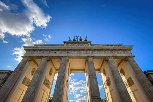 Low angle view of Brandenburg Gate in Berlin, Germany against blue sky with clouds