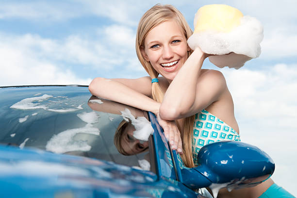 笑顔の女性の車を洗う - car women cleaning sports car ストックフォトと画像