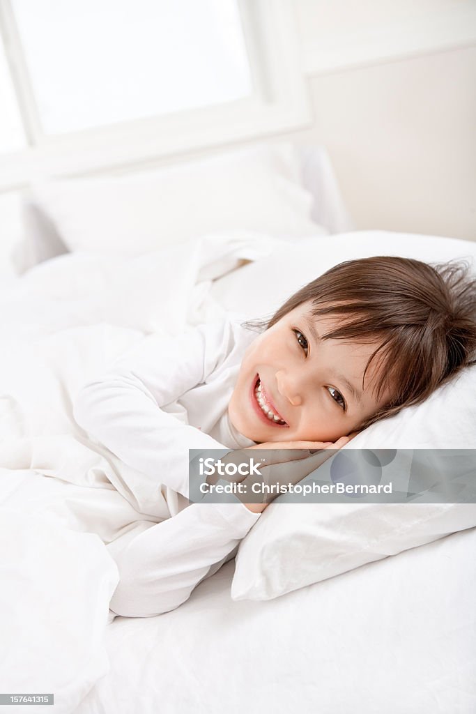 Uśmiechnięta dziewczynka leżąc w łóżku - Zbiór zdjęć royalty-free (4 - 5 lat)