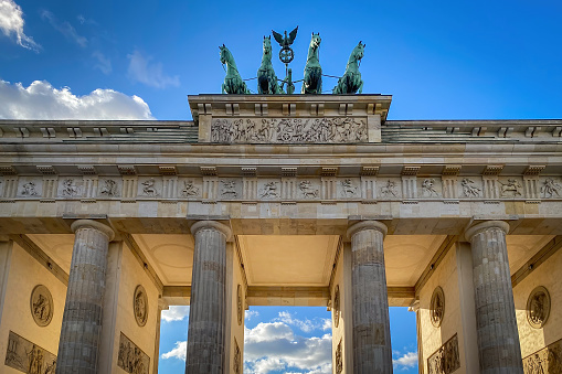 Low angle view of Brandenburg Gate in Berlin, Germany against blue sky with clouds