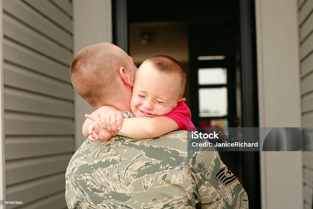 Happy return of military father holding his son Military dad hugging his son tightly. Military Stock Photo