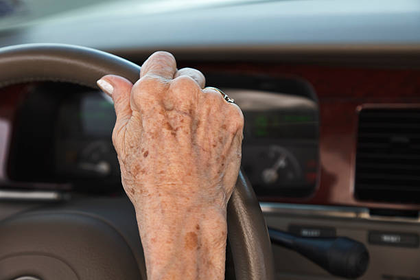 senior woman hand on steering wheel Senior woman driving car with hand on steering wheel. dashboard close up speedometer odometer stock pictures, royalty-free photos & images