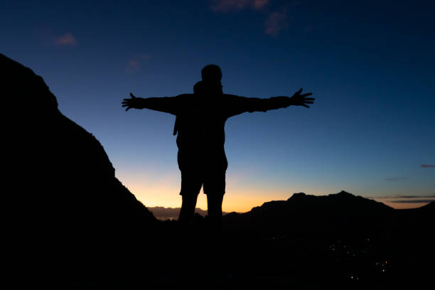 istock Young man on a hike silhouetted against a sunset 1576414072