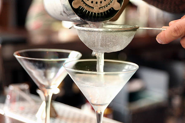 eingießen martinis - salatsieb stock-fotos und bilder