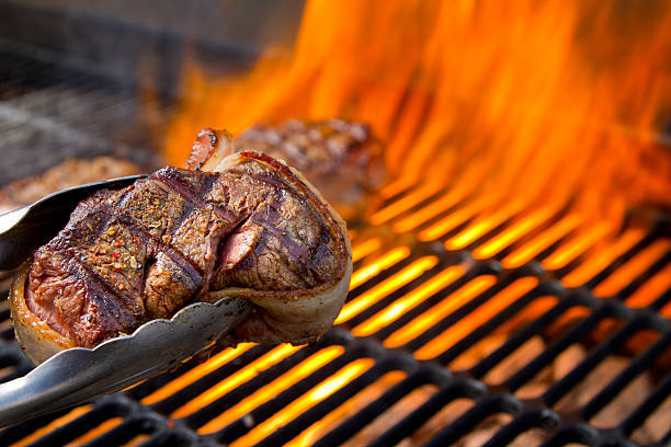 pancetta avvolto manzo filet mignon sulla griglia con fiamme di danza - meat steak filet mignon sirloin steak foto e immagini stock