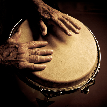 old man hands playing latin percussion (tumbadora or congas)