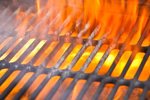 Old fashioned backyard charcoal barbecue grill with huge flames leaving large amounts of copy space for titles and other content