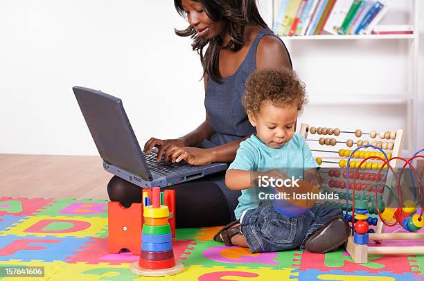 Photo libre de droit de Une Femme Daffaires Afroaméricain Travaillant Tandis Que Son Fils Jouant banque d'images et plus d'images libres de droit de Boulier