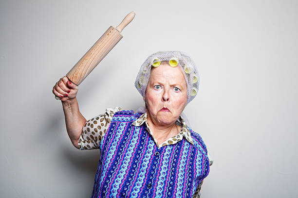 angry retro senior housewife with rolling pin