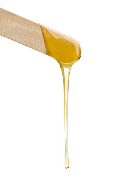 Wax Wax dripping from a spatula isolated on white. waxing stock pictures, royalty-free photos & images