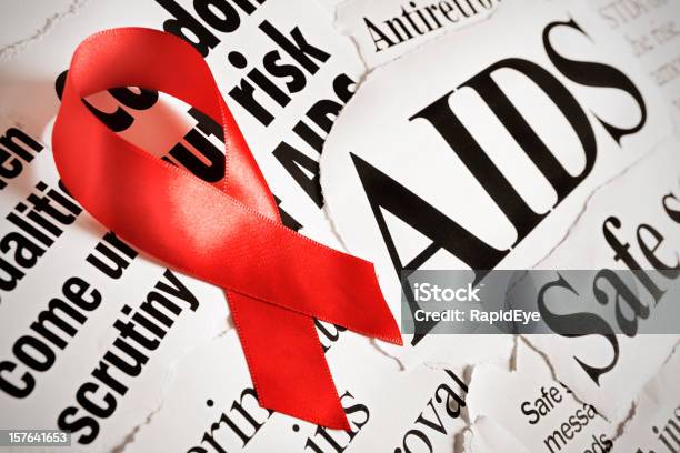 Red Aids Ribbon On Headlines About Aspects Of The Disease Stock Photo - Download Image Now