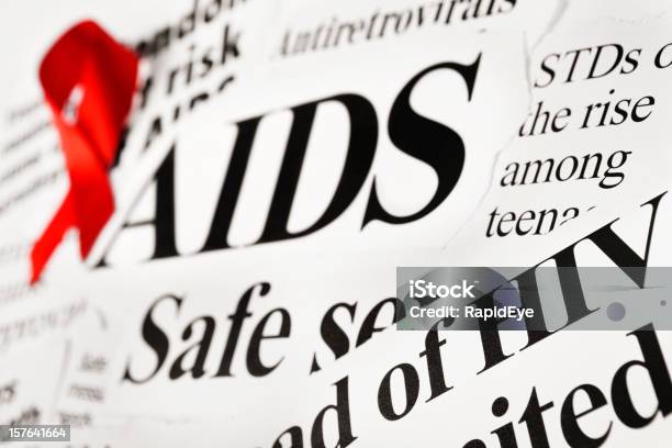 Red Awareness Ribbon On Aids Related Newspaper Headlines Stock Photo - Download Image Now