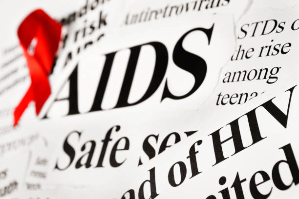 czerwona wstążka świadomości na aids z nagłówków gazet - hiv aids condom sex zdjęcia i obrazy z banku zdjęć