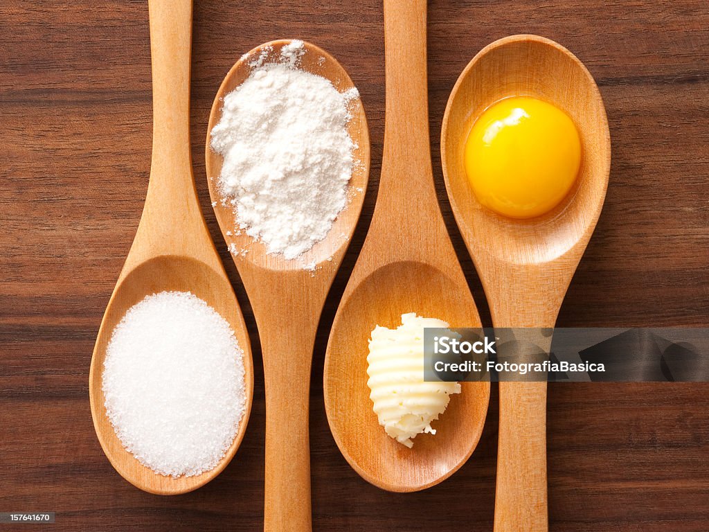 Baking ingredients Top view of wooden spoons containing baking ingredients (sugar, flour, butter, egg) Flour Stock Photo